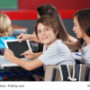 Boy With Girl Using Digital Tablet At Desk
