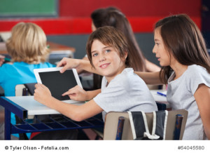 Boy With Girl Using Digital Tablet At Desk
