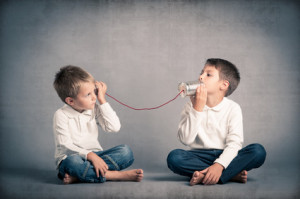 Young brothers talking with tin can telephone