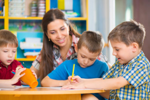 Cute children drawing with teacher at preschool class