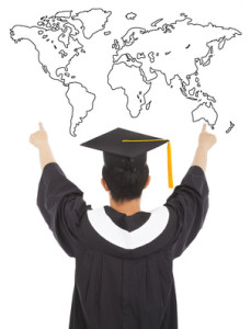 graduation man wearing a mortarboard and point to world